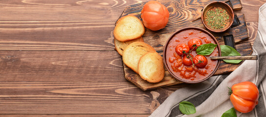 Composition with tasty tomato cream soup on wooden background with space for text