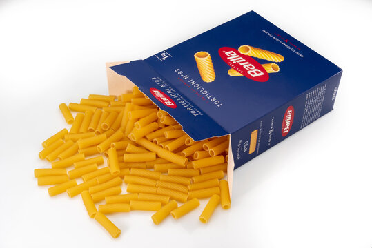 Turin, Italy - october 15, 2022: Macaroni tortiglioni pasta Barilla come out of blue package isolated on white, Barilla is world famous Italian pasta factory