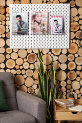 Pegboard with magazines on wooden wall in living room