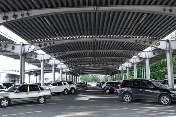 Cars parked under canopy near supermarket