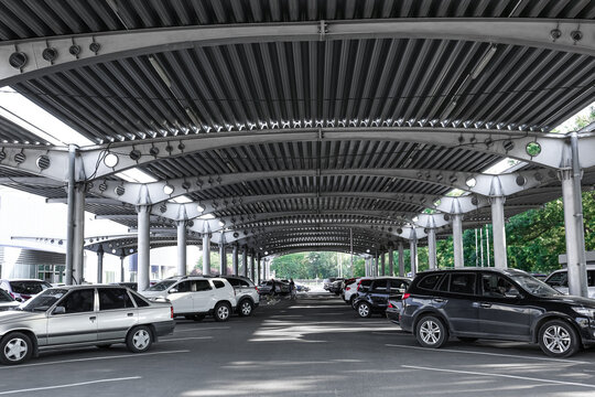 Cars parked under canopy near supermarket - Powered by Adobe