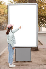 Woman near blank advertising billboard on city street