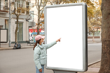 Woman near blank advertising billboard on city street