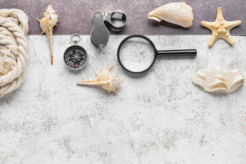 Compass, magnifiers, rope and seashells on grunge background