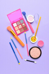 Set of different makeup brushes and decorative cosmetics on color background