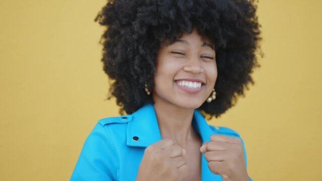 Cinematic video of a self confident young woman spending time in a modern city. Millennial girl with afro hairstyle lifestyle moments.