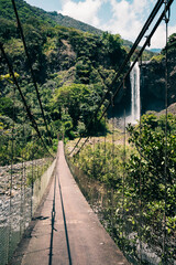 Suspension bridge leading to waterfall 