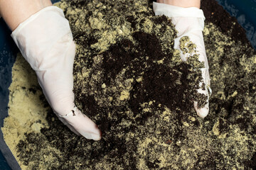 The person mixes soil with sand. Top view.