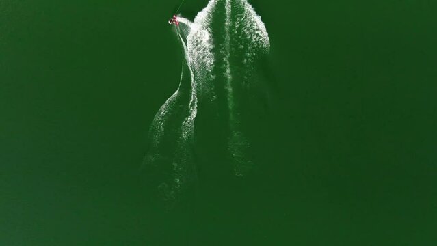 Aerial shot of a wakeboarder and boat in the lake