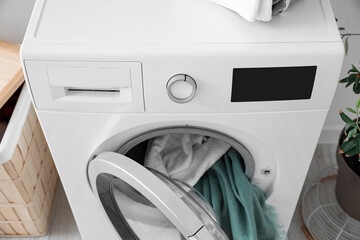Washing machine with towels in laundry room, closeup