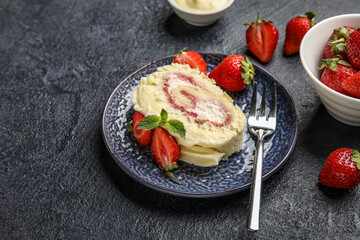 Plate with slice of tasty strawberry roll cake on dark background