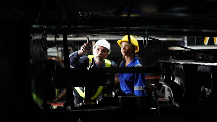 Group of apprentices with instructor at railway engineering facility. Teacher talking to apprentices at railway engineering facility