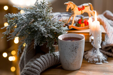 A Christmas card with a vintage horse, candles and a mug of hot coffee on the background of a...