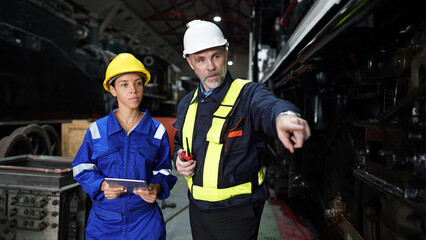 Group of apprentices with instructor at railway engineering facility. Teacher talking to apprentices at railway engineering facility