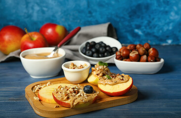 Board of fresh apples with nut butter on color wooden table