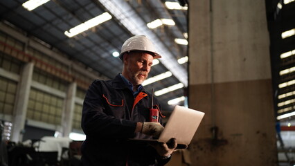 Factory engineer or foreman worker maintaining check equipment parts in factory.