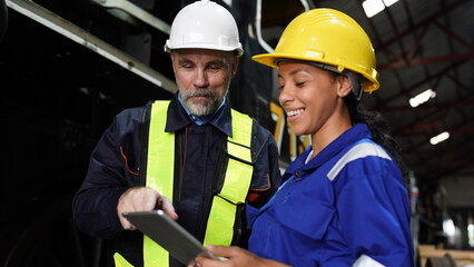 Group of apprentices with instructor at railway engineering facility. Teacher talking to apprentices at railway engineering facility