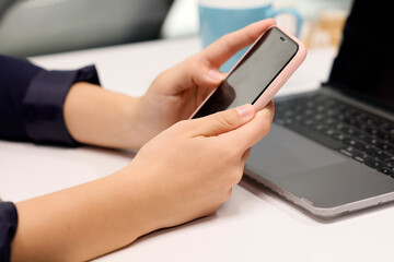 A woman writes a text message on his phone. Person texting text message using in hands mobile phone, closeup.