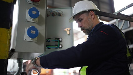 Engineers working at Factory in powerplant and maintenance check on electric control box in factory.