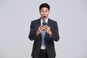 asian businessman using smartphone and surprise to receive notification isolated on studio white...