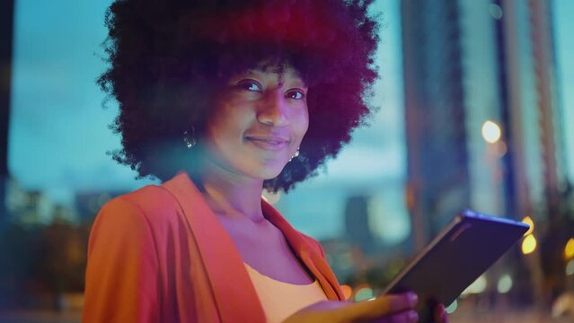 Cinematic video of a self confident young woman spending time in a modern city. Millennial girl with afro hairstyle lifestyle moments.