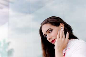 young transgender wearing headphones and talking on his mobile phone