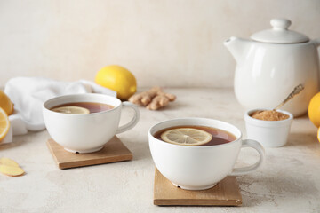 Stands with cups of black tea and lemon on white background, closeup