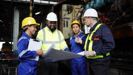 Engineers in discussion in machine maintenance in factory. Group of Industrial Engineers with...