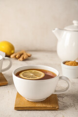 Stand with cup of black tea and lemon on white background, closeup