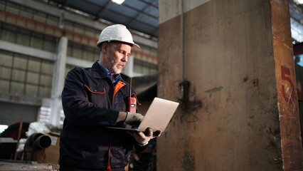 Factory engineer or foreman worker maintaining check equipment parts in factory.