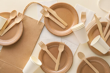 Eco tableware and paper bags on white background
