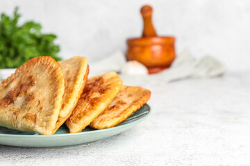 Plate with tasty chebureks on light table