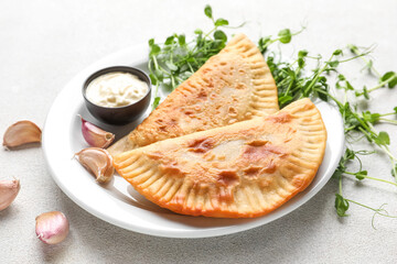 Plate with tasty chebureks and sauce on table, closeup