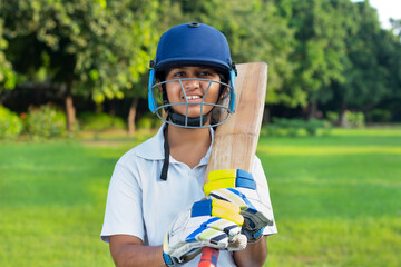 Fototapeta na wymiar Portrait Of A Female Cricketer Holding A Cricket Bat