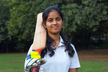 Portrait Of A Female Cricketer Holding A Cricket Bat