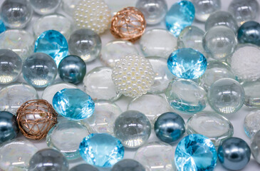 Beautiful background of transparent, light blue glass beads, crystals and white pearls. Copy space