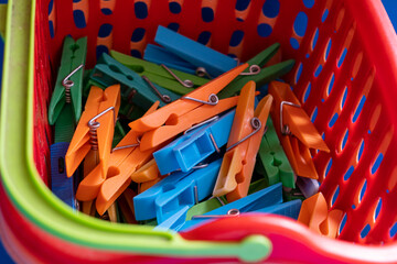 Close-up of colorful plastic clothespins inside a plastic basket