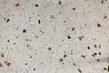 Terrazzo floor. Light colorful texture. Multicolor background – beige, green, orange, yellow, ochre, mustard, red, and brown. Small, medium polish rocks