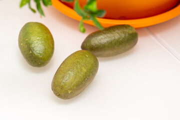 Ripe burgundy green finger-shaped citrus fruits on the dinner table, close-up. Indoor growing of the outlandish citrus plant Australian finger lime, Microcitrus Australasica