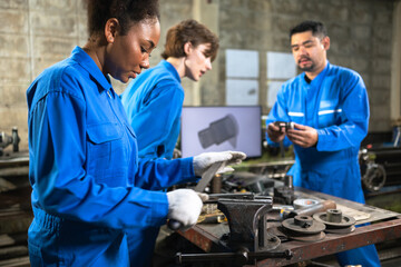 Obraz premium Engineer senior asian man and african woman wearing safety helmet working and checking machine automotive part warehouse. Factory for the manufacture and processing.