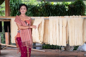 Local woman dressed in traditional Balinese sarong demonstrates a batik suit selection
