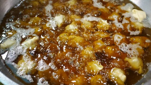 coking Singara in hot oil in a big cooking pan 