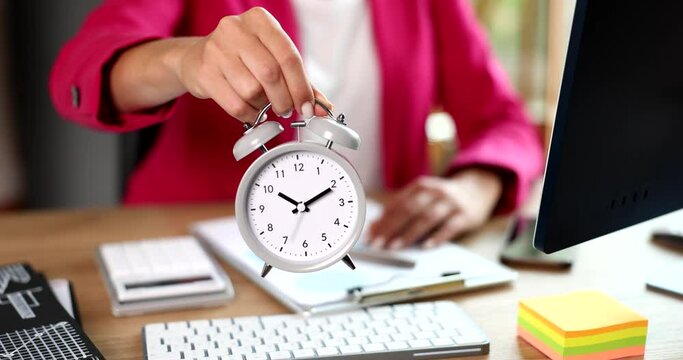Businesswoman showing time on alarm clock on desktop closeup 4k movie slow motion