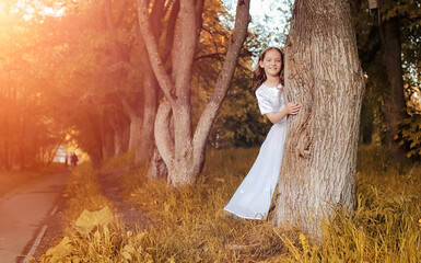 Teen blowing seeds from a dandelion flower in a park