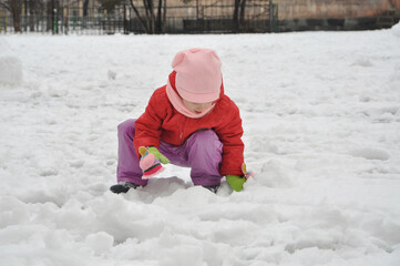 Fototapeta na wymiar Winter day. The child plays with snow. Snow meadow.