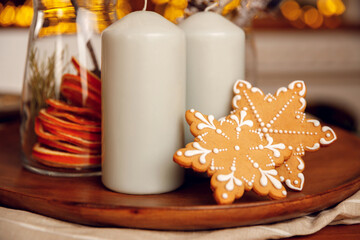 gingerbread cookie on a wooden plate. For recipes. Festive table setting. Home comfort and warm atmosphere. New Year and Christmas. Baking for dessert. Candles and garland
