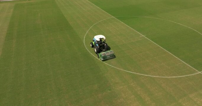 Mowing a soccer field green grass in perfect lines, Aerial view