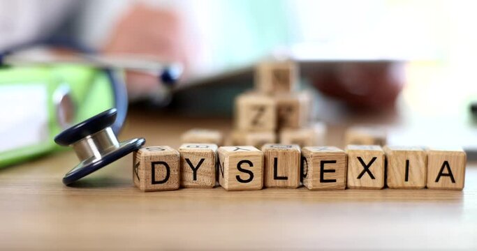 Word dyslexia is written on cubes on doctor table closeup 4k movie slow motion