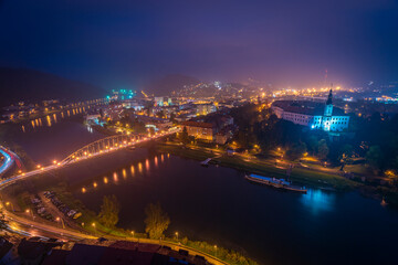 Decin town from above in dark mist evening in autumn