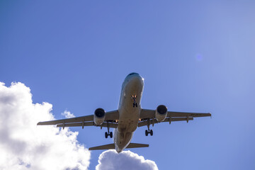 A big white airplane flying in the blue sky with many white and dark blue clouds